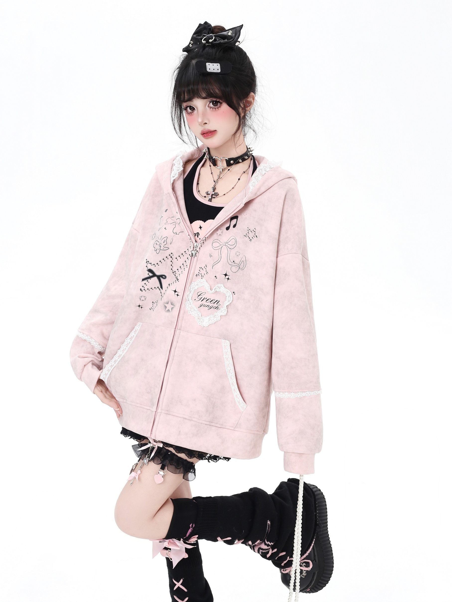 Person wearing a pink hoodie with decorative elements on a white background