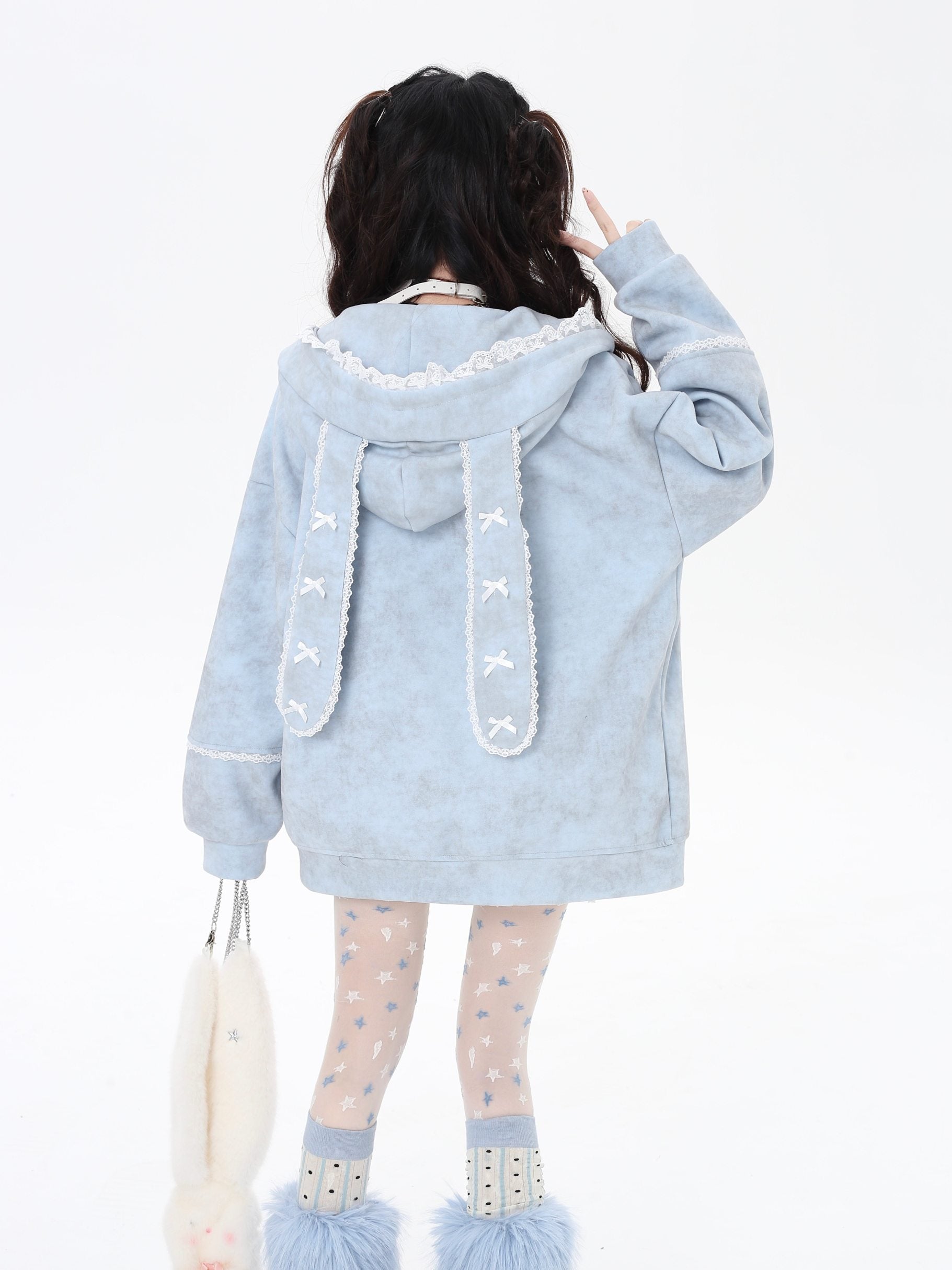 Light blue hoodie with bunny ears and tail worn by a person on a white background