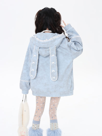 Light blue hoodie with bunny ears and tail worn by a person on a white background
