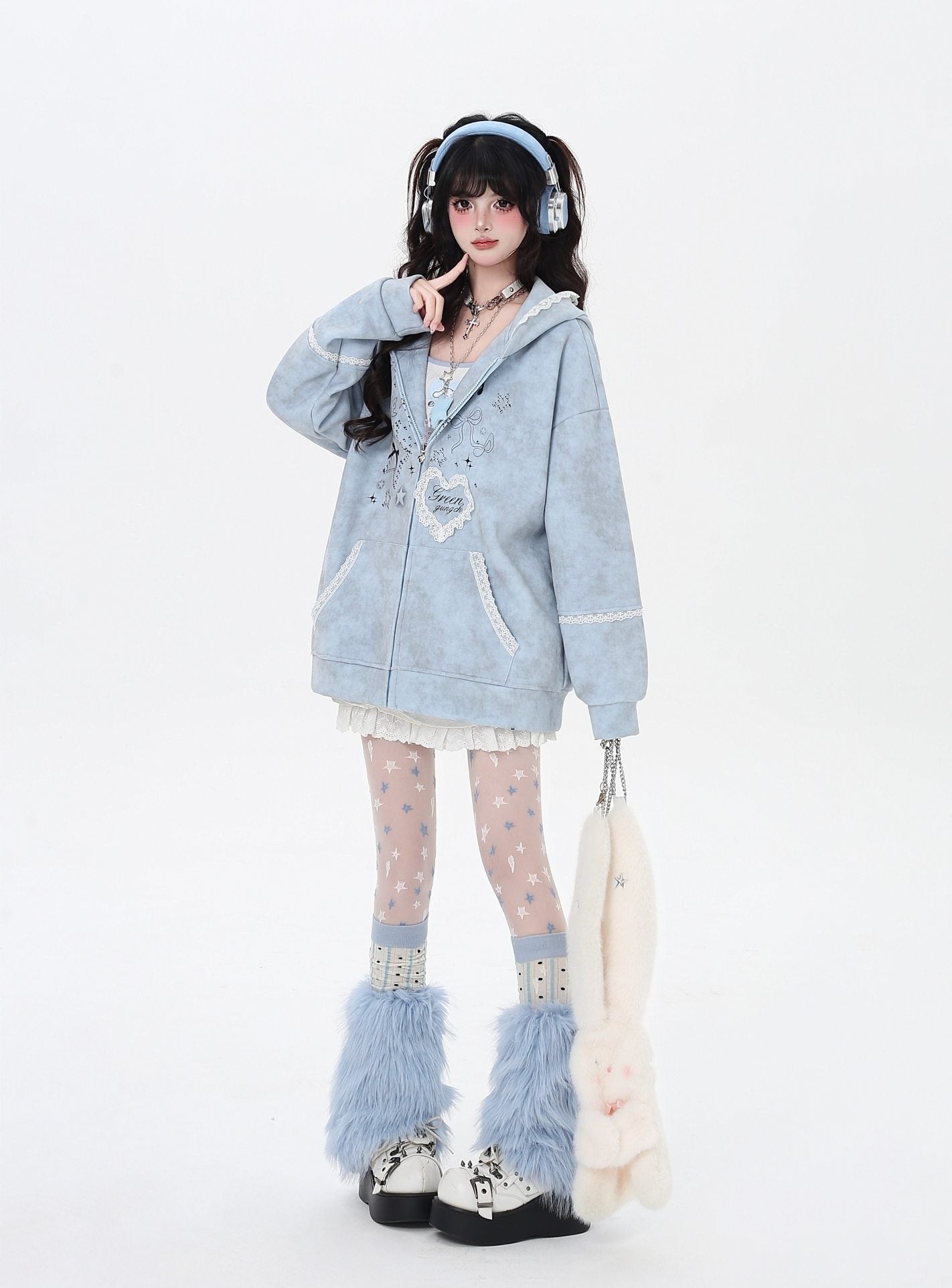 Person wearing a light blue hoodie with decorative elements, white tights, and fluffy boots on a white background