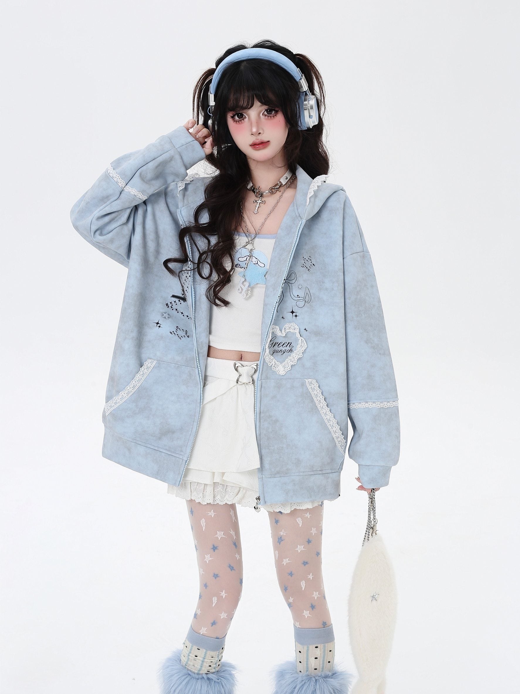 Person wearing a light blue hoodie with decorative elements on a white background