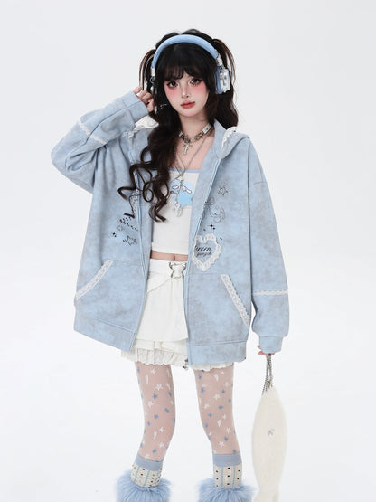 Person wearing a light blue hoodie with decorative elements on a white background