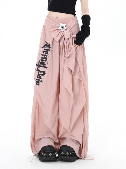 Pink wide-leg pants with black text and graphics on a white background