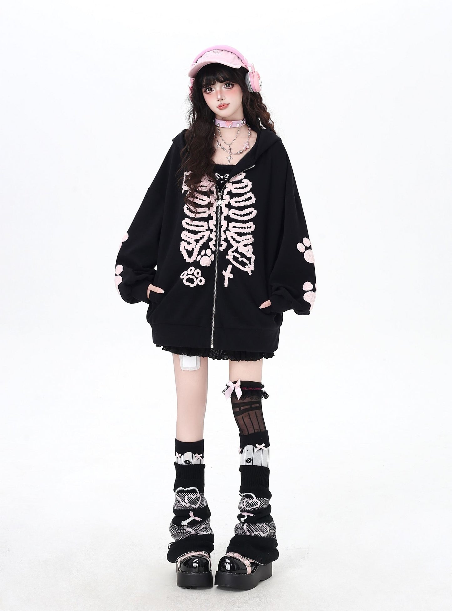 Person wearing a black skeleton hoodie with white accents on a white background