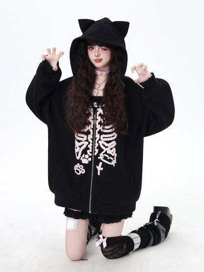Person wearing a black hoodie with cat ears and skeleton design on a white background