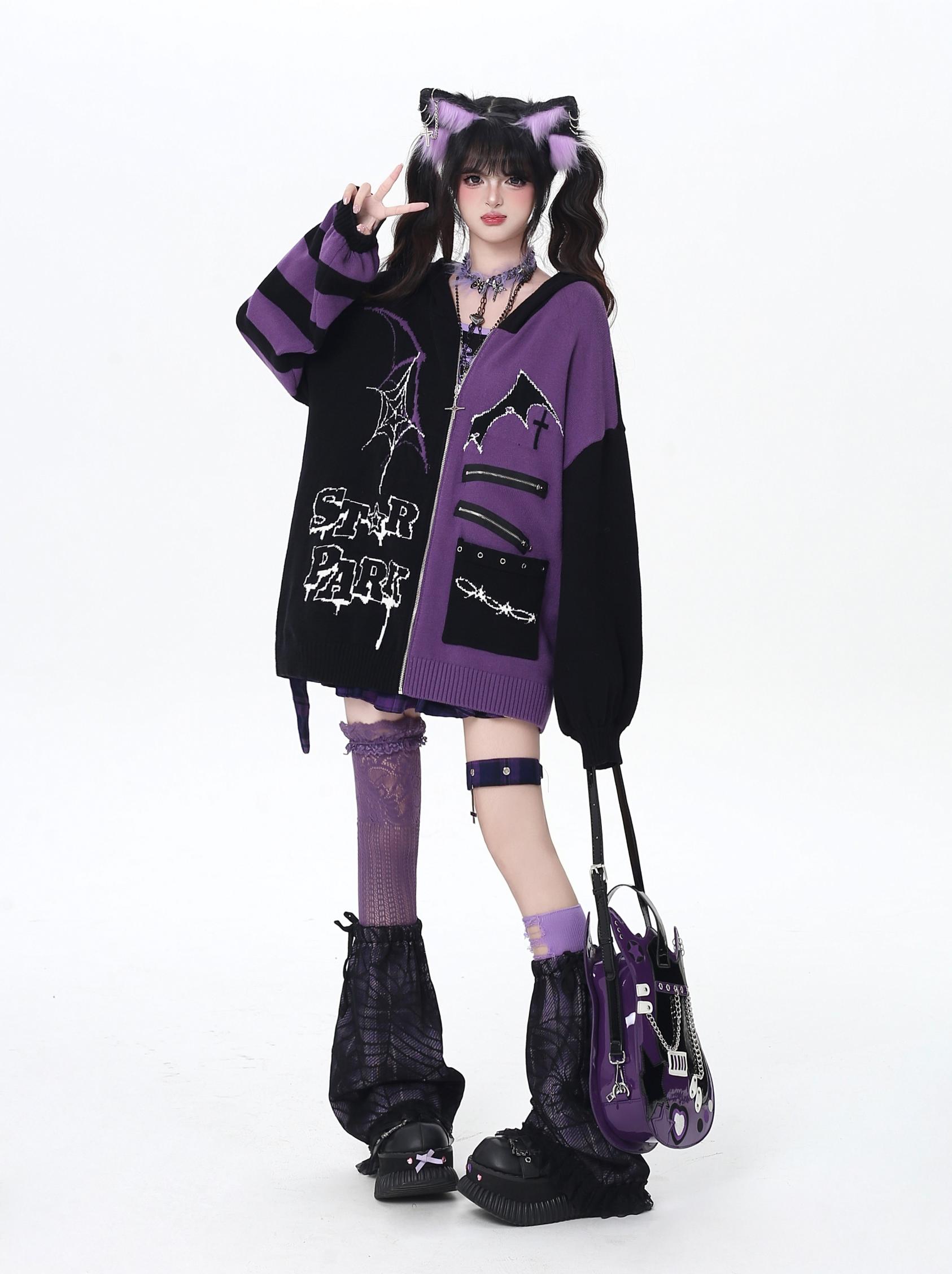 Person wearing a black and purple outfit with cat ears, holding a matching bag on a white background