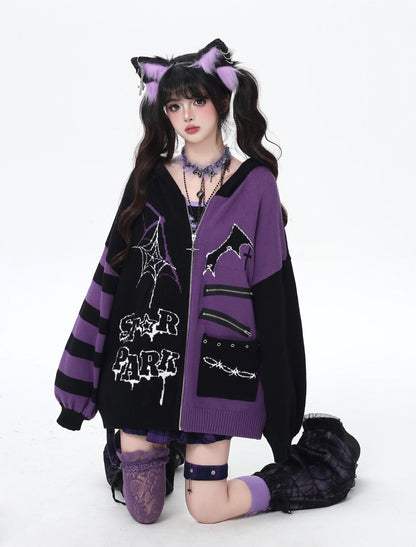 Person wearing a black and purple outfit with cat ears and a cardigan on a white background