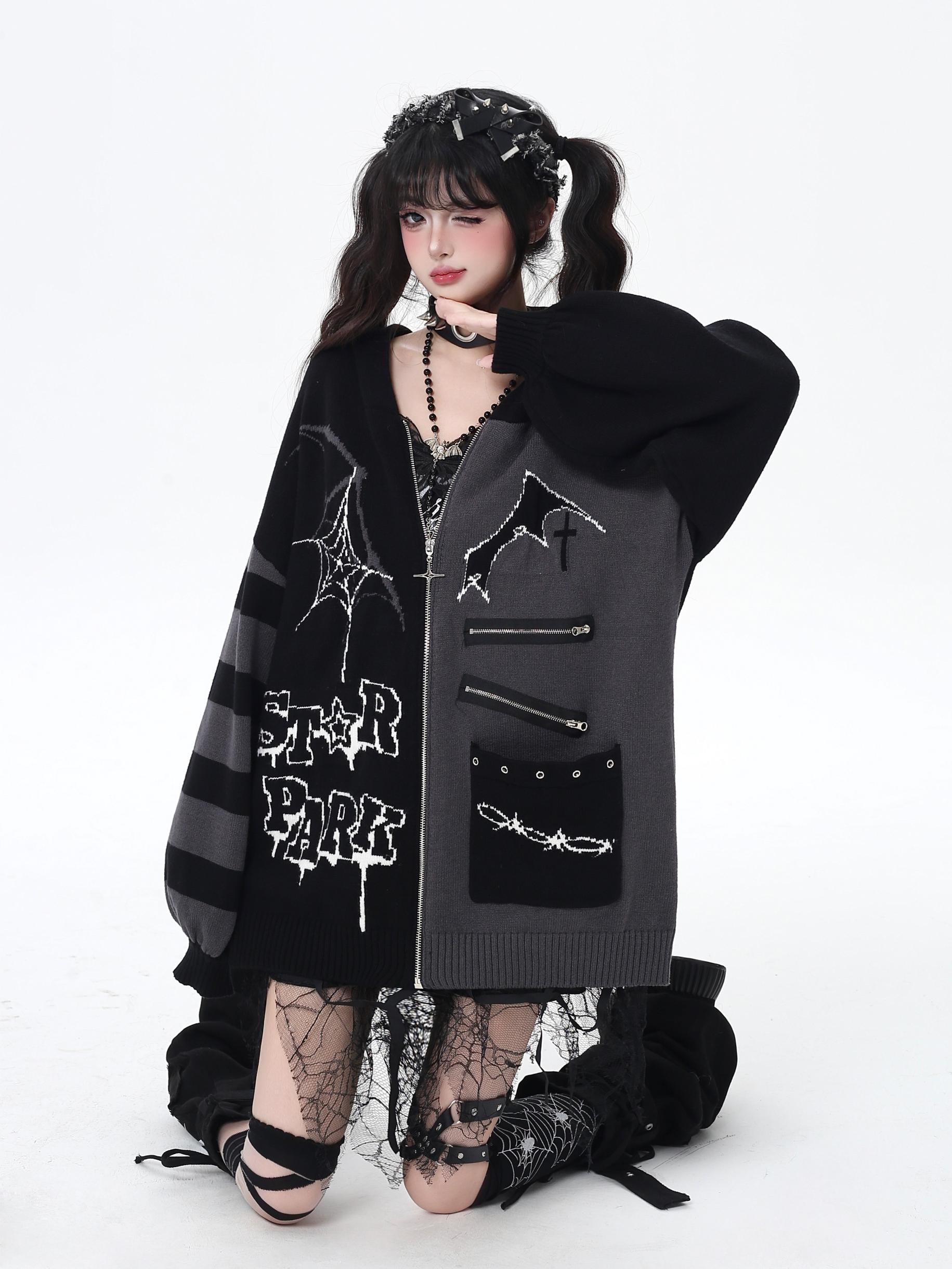 Person wearing a dark, stylish coat with spider web designs on a white background