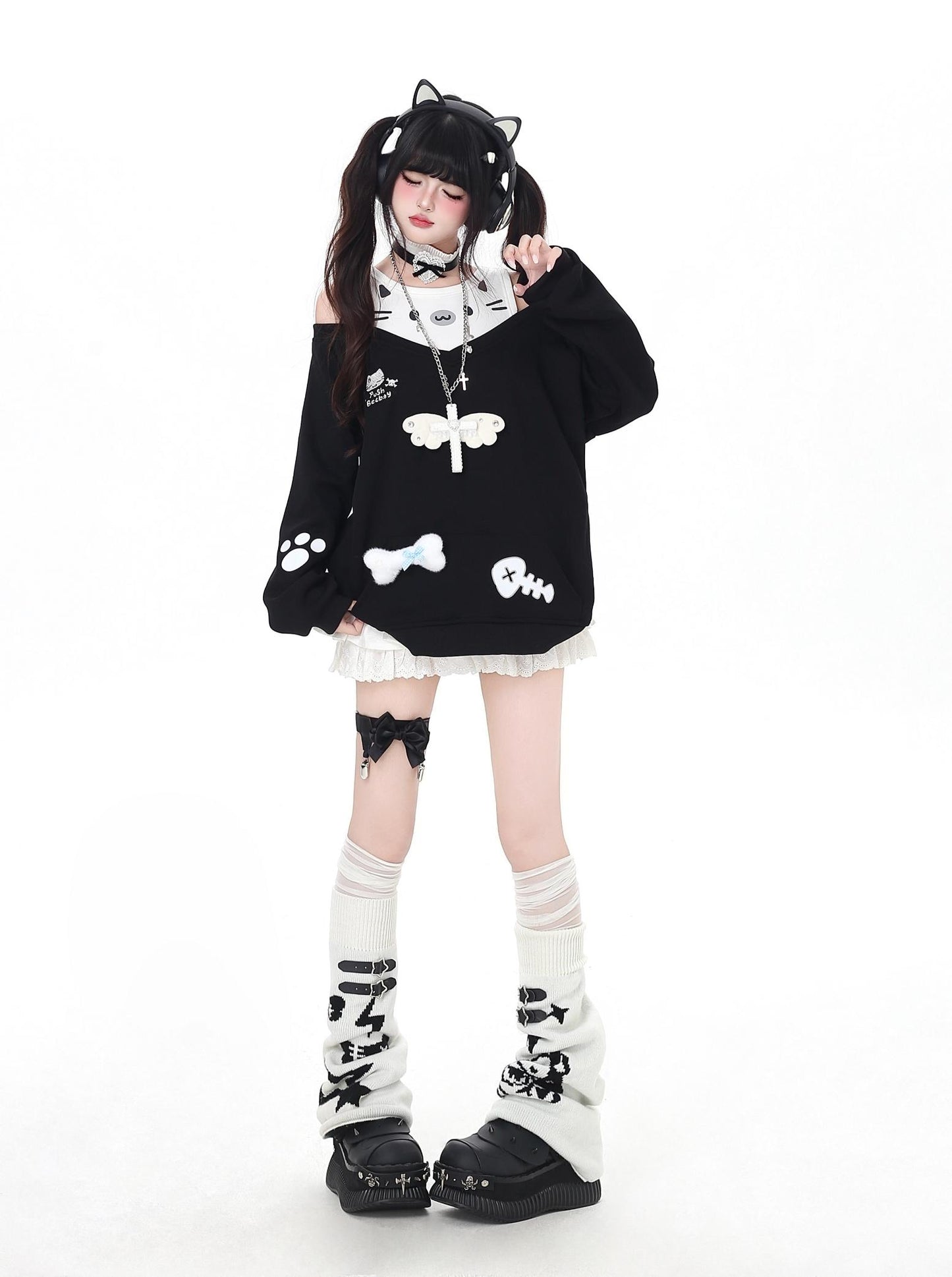 Person wearing a black and white outfit with cat-themed design on a white background
