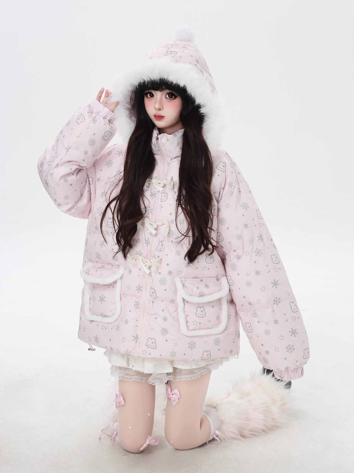 Person wearing a pink winter coat with fur trim on a white background