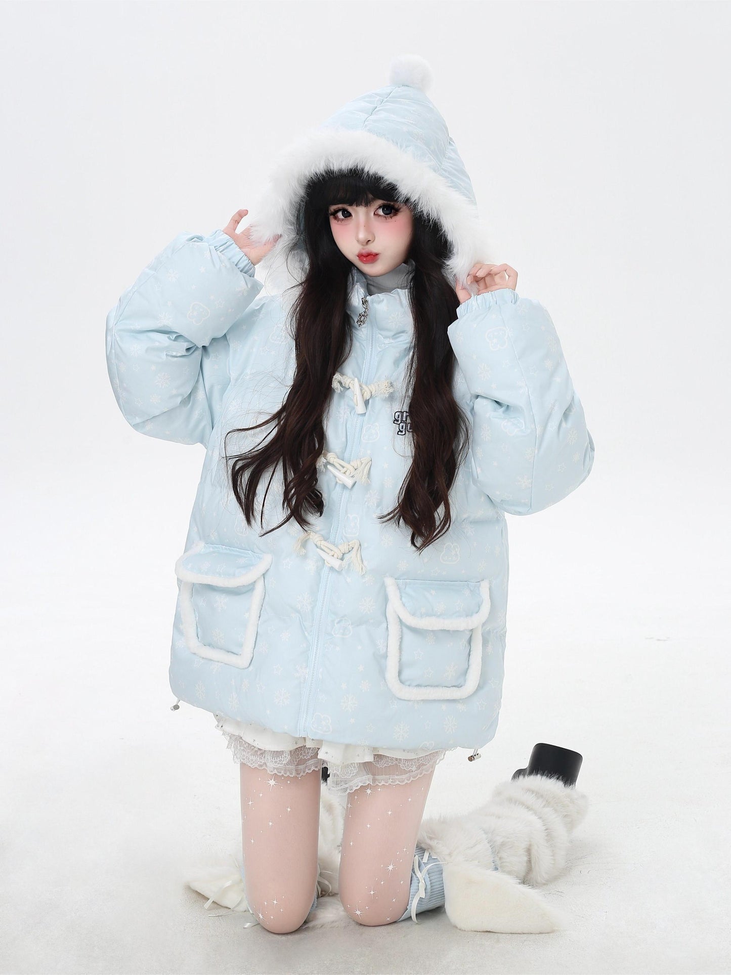 Person wearing a light blue winter coat with white fur trim on a white background