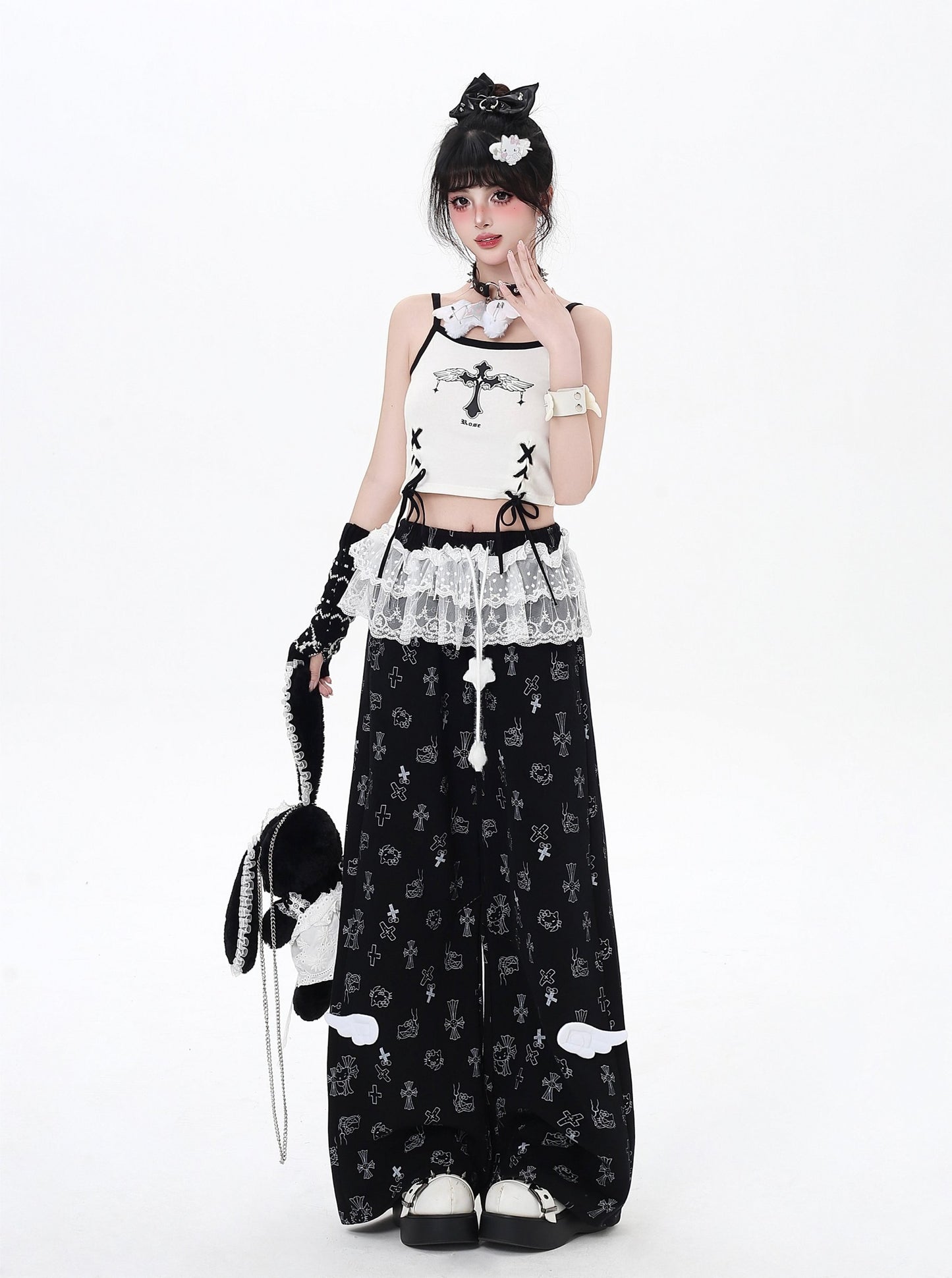 Person wearing a black and white outfit with lace details on a white background