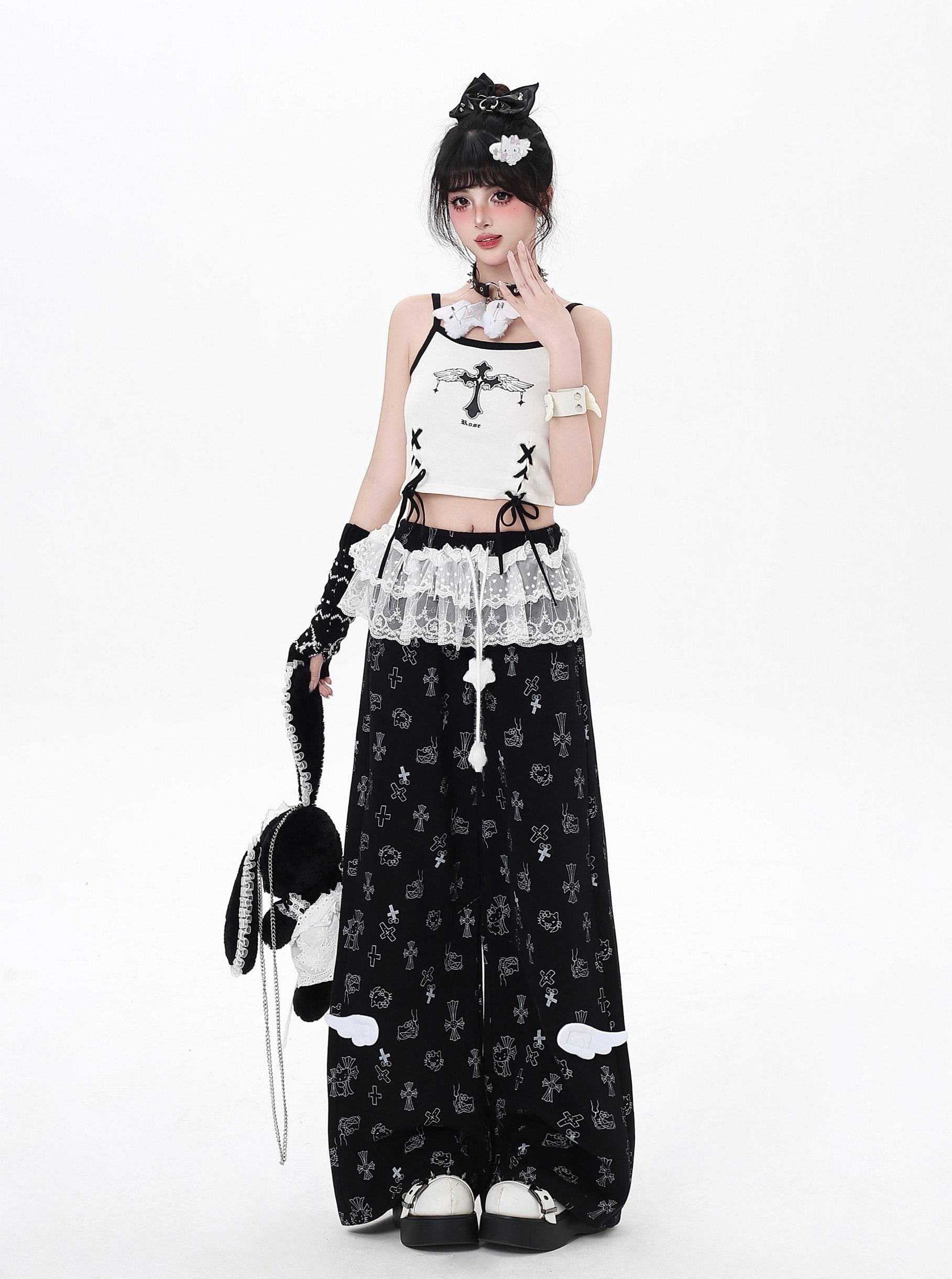 Person wearing a black and white outfit with lace details on a white background