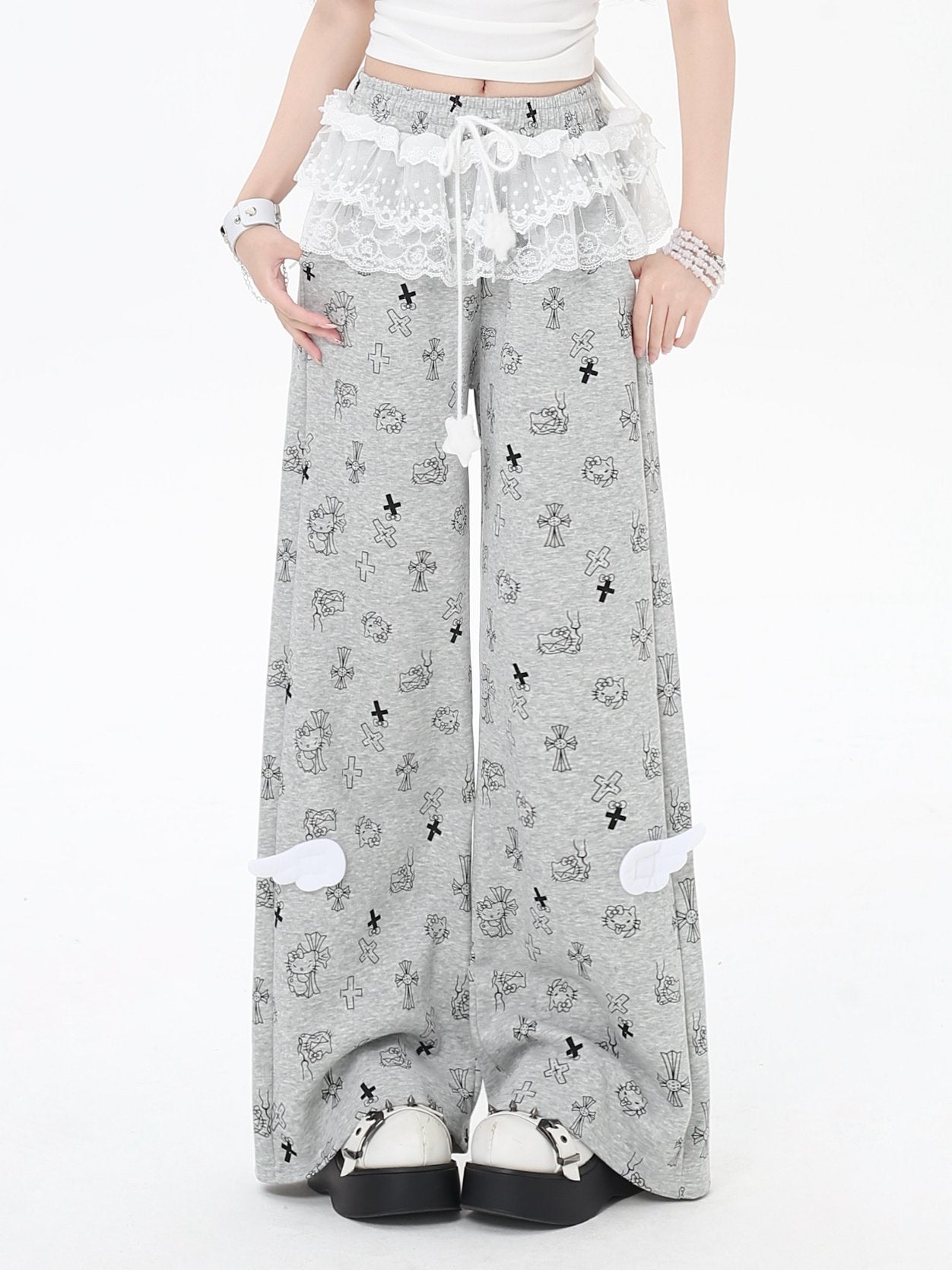 Person wearing gray wide-leg pants with a pattern, standing against a white background