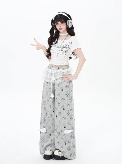 Person wearing a white crop top and gray pants with a pattern, posing on a white background