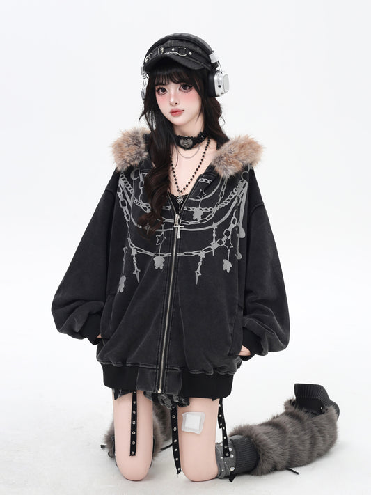 Person wearing a black hoodie with fur trim and decorative elements on a white background