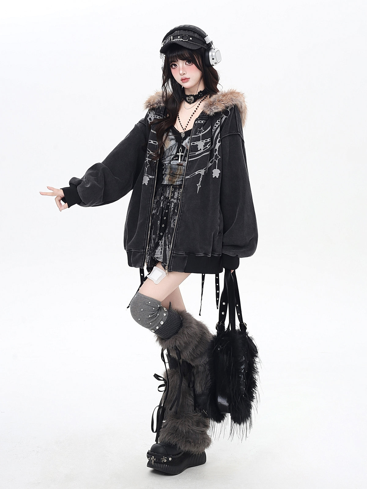 Person wearing a dark coat with fur trim and high boots on a white background