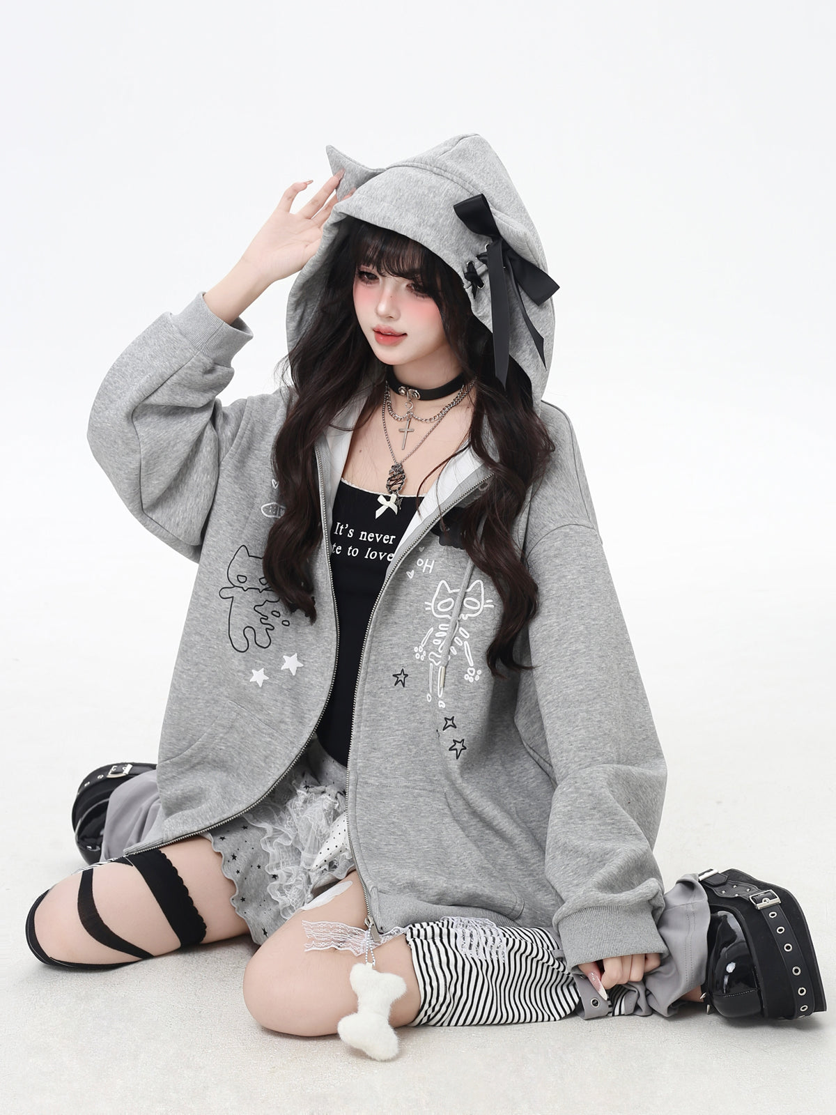 Person wearing a gray hoodie with animal ears on a white background