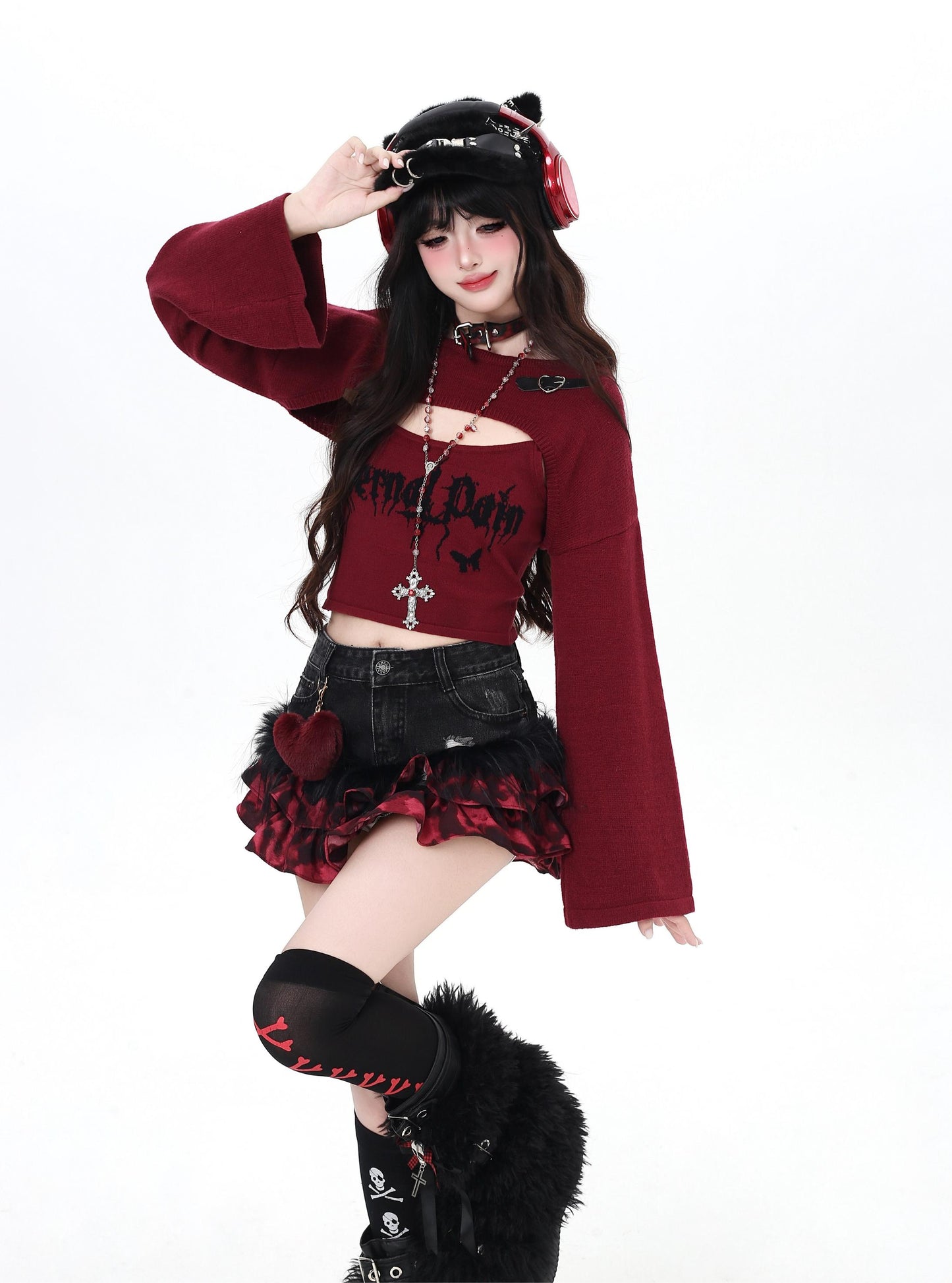 Person wearing a gothic-style outfit with a red top and black skirt on a white background