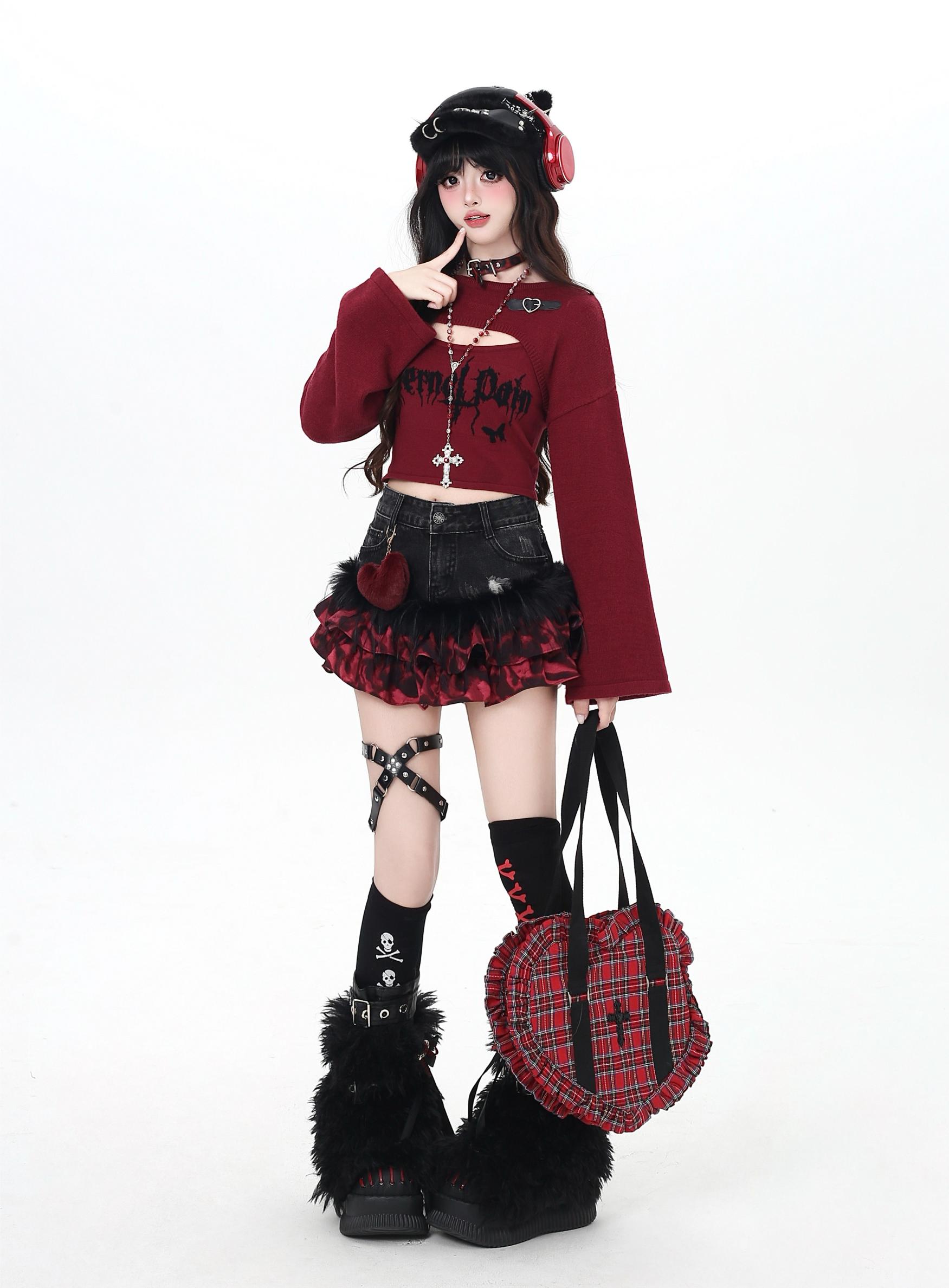 Person wearing a gothic Lolita outfit with a red sweater, black skirt, and plaid bag on a white background