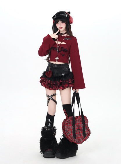 Person wearing a gothic Lolita outfit with a red sweater, black skirt, and plaid bag on a white background