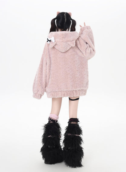 Person wearing a fluffy pink hoodie with cat ears and black furry boots on a white background