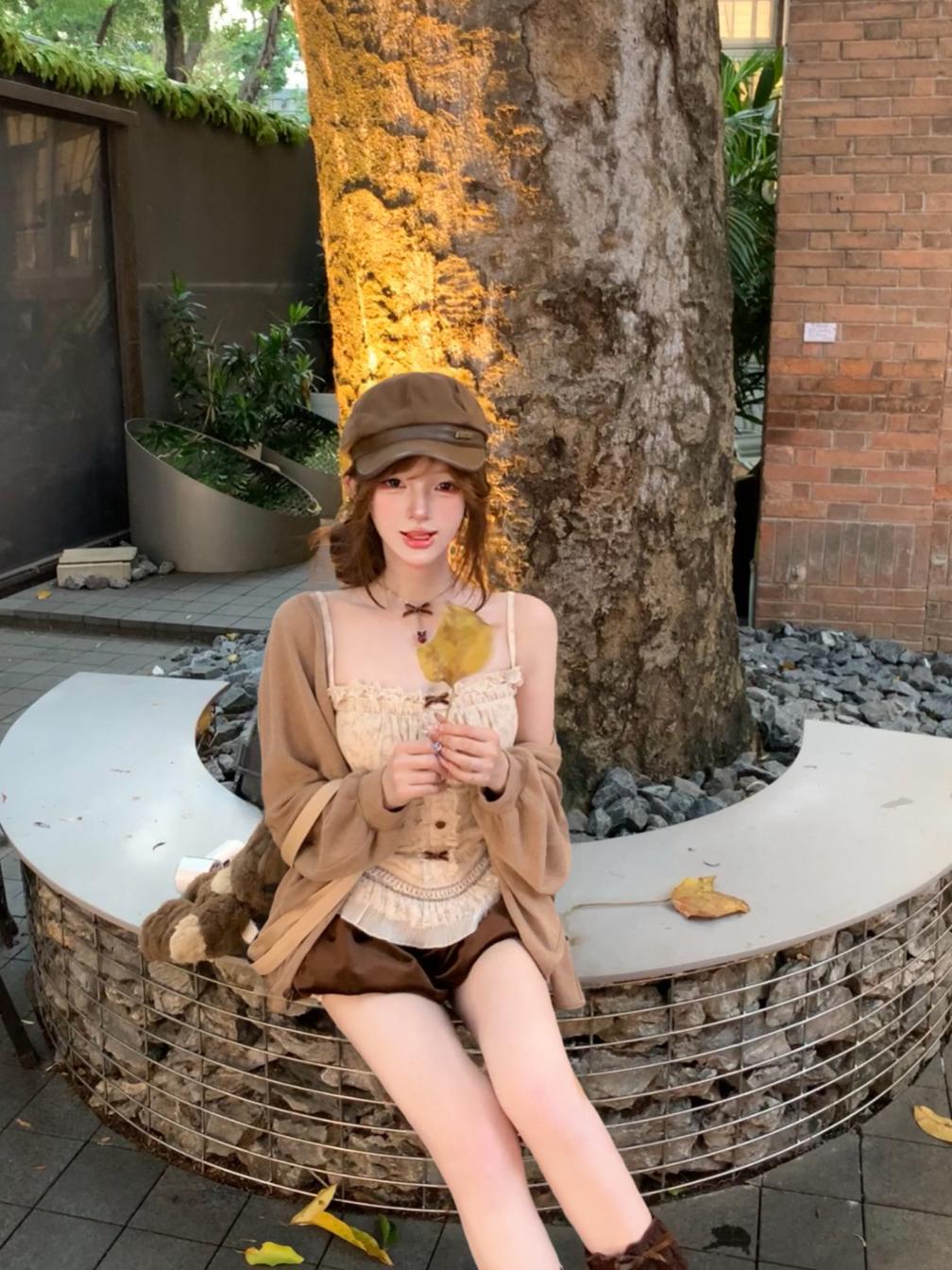 Woman sitting on a circular stone bench outdoors with a tree and building in the background