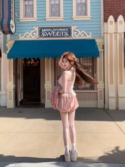 Woman in a coquette pink dress standing in front of a building with a blue awning.