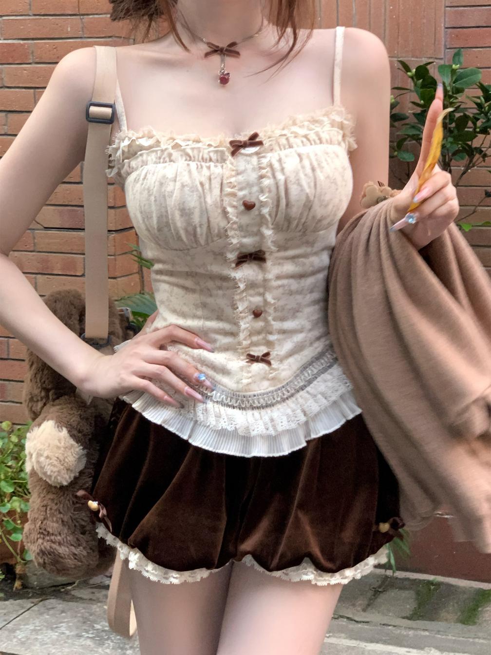 Person wearing a coquette beige top with lace details and a brown skirt outdoors.