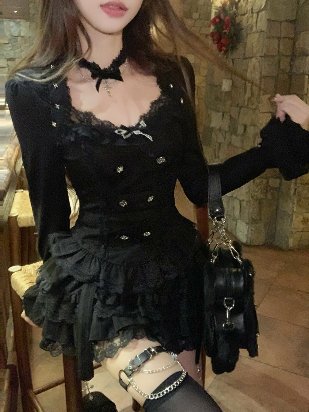 Person wearing a black lace dress with a stone wall background