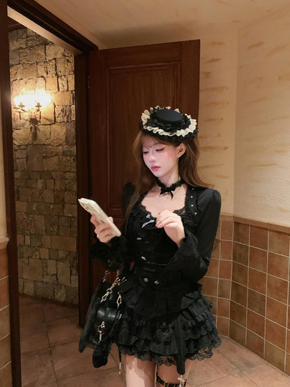 Woman in a black outfit with floral headpiece standing in a room with stone walls and wooden door.