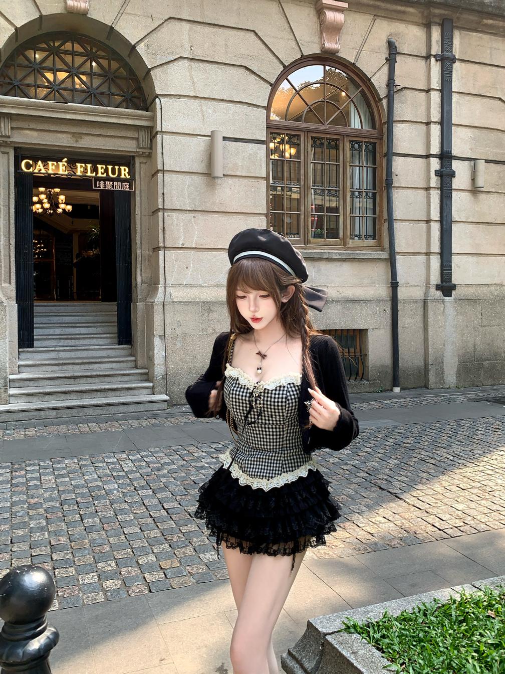 Woman in a black dark coquette stylish outfit standing in front of a building with 'Café Fleur' sign.