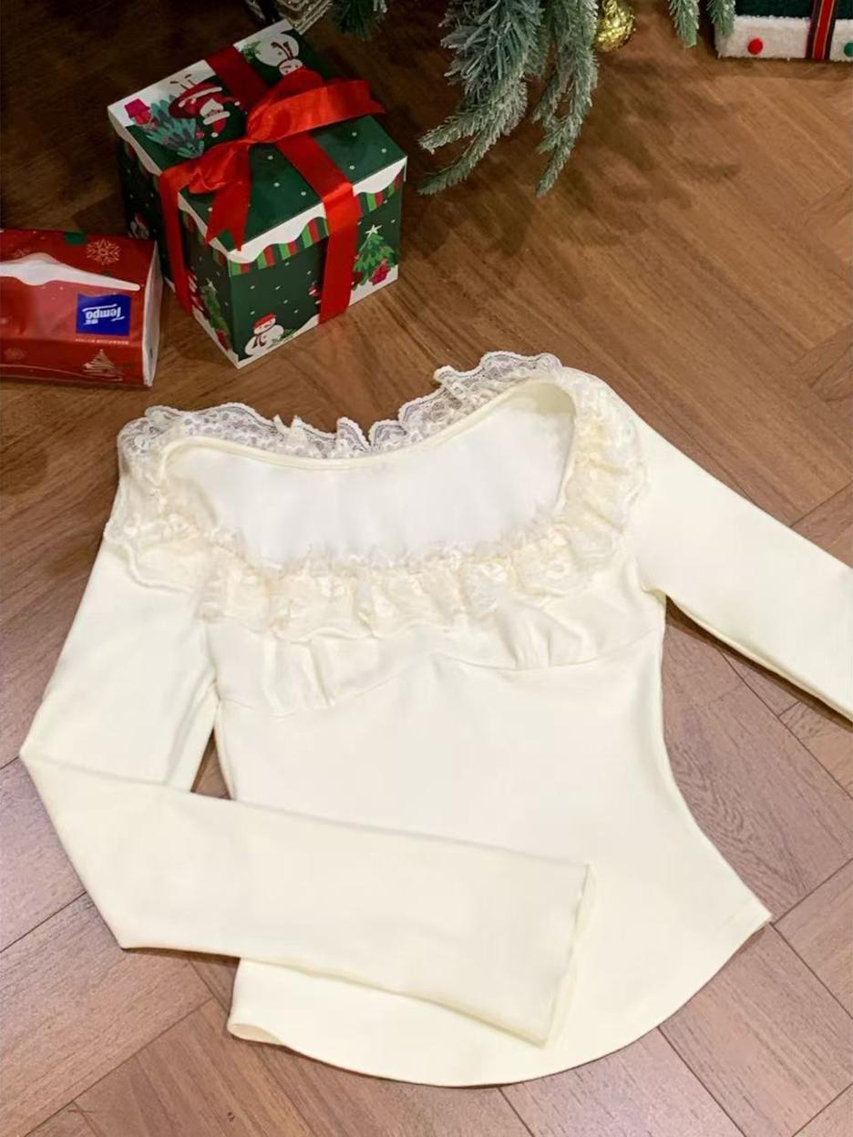 White blouse with lace details on a wooden floor with Christmas presents in the background