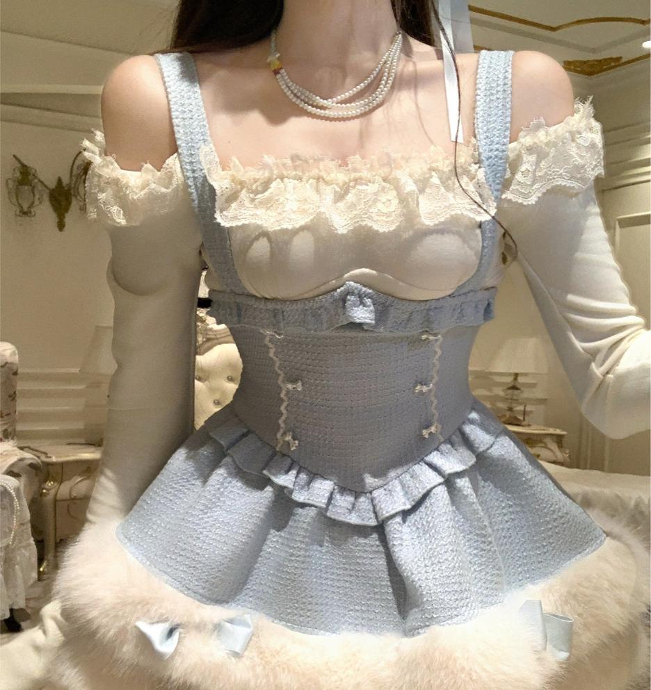 Person wearing a light blue cute winter outfit with lace details in an indoor setting.