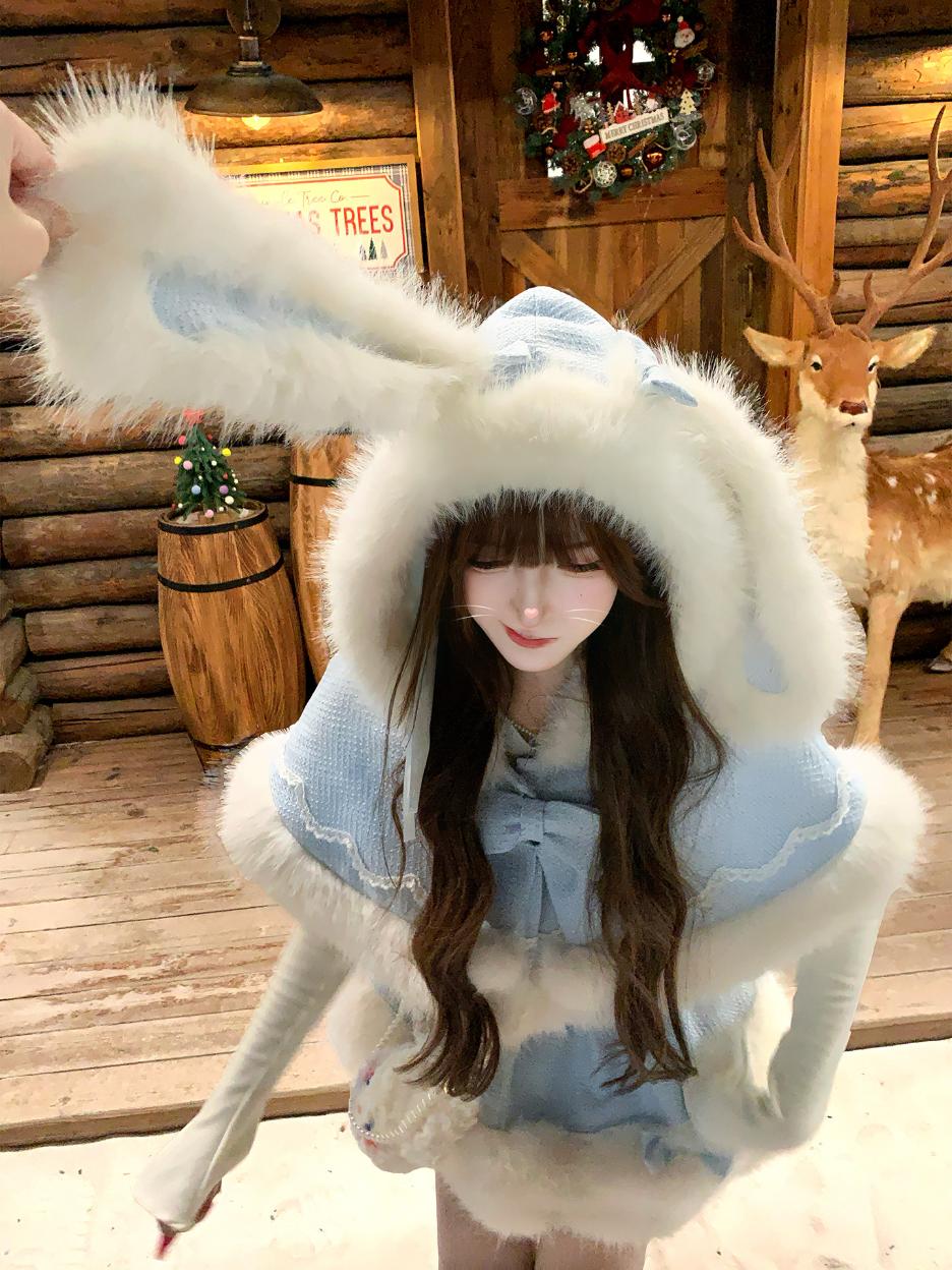 Person wearing a fluffy white hood with bunny ears in a rustic wooden cabin setting.