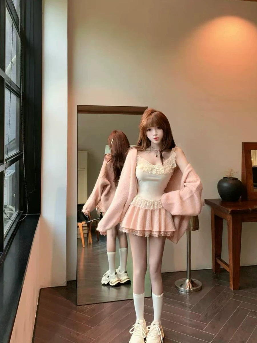 Woman in a coquette pink outfit standing in front of a mirror in a room.