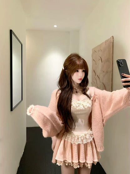 Person wearing a coquette pink outfit with a white lace top and skirt, standing in a room.