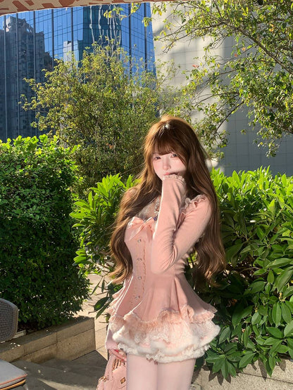Woman in a pink dress standing outdoors with greenery and buildings in the background