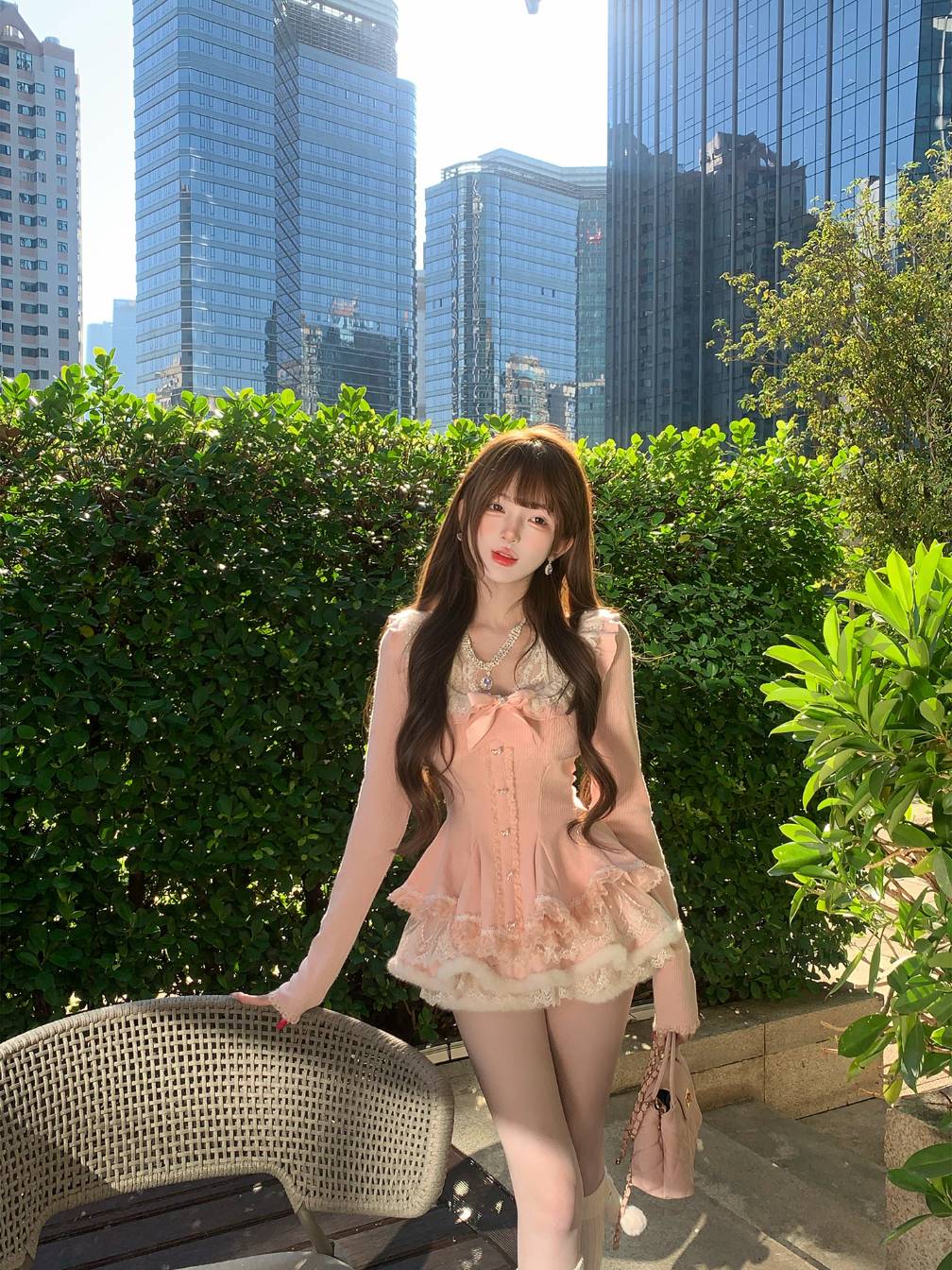 Woman in a pink dress standing outdoors with city skyline in the background