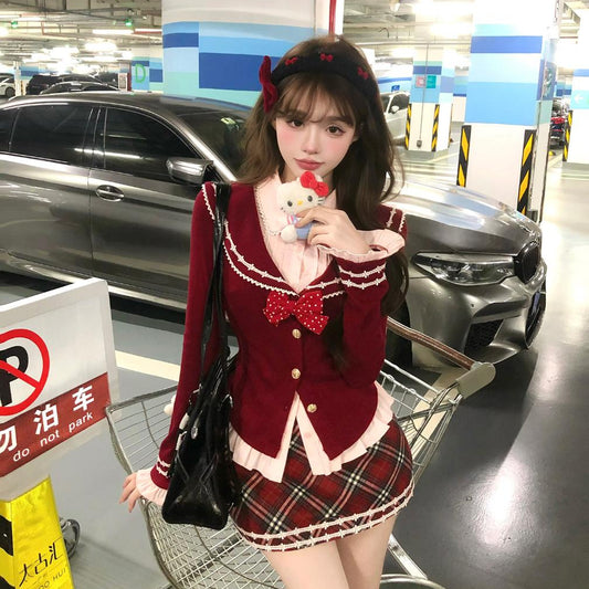 Person in a red outfit with a bow tie standing in a parking garage holding a plush toy.