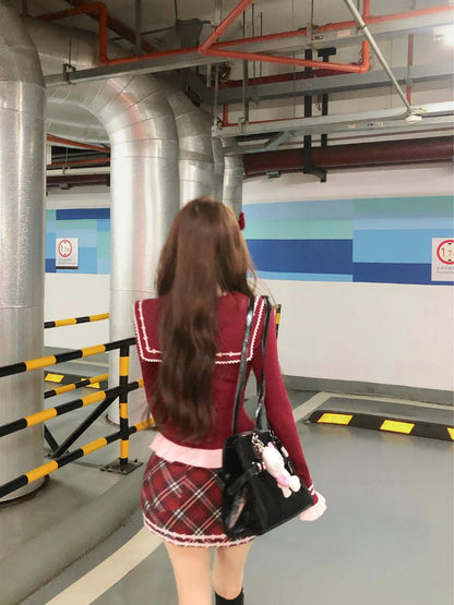 Person in a school uniform standing in an indoor setting with pipes and barriers.
