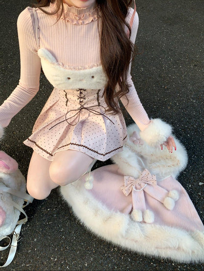 Person wearing a pink cute outfit with a fluffy white skirt on a dark surface