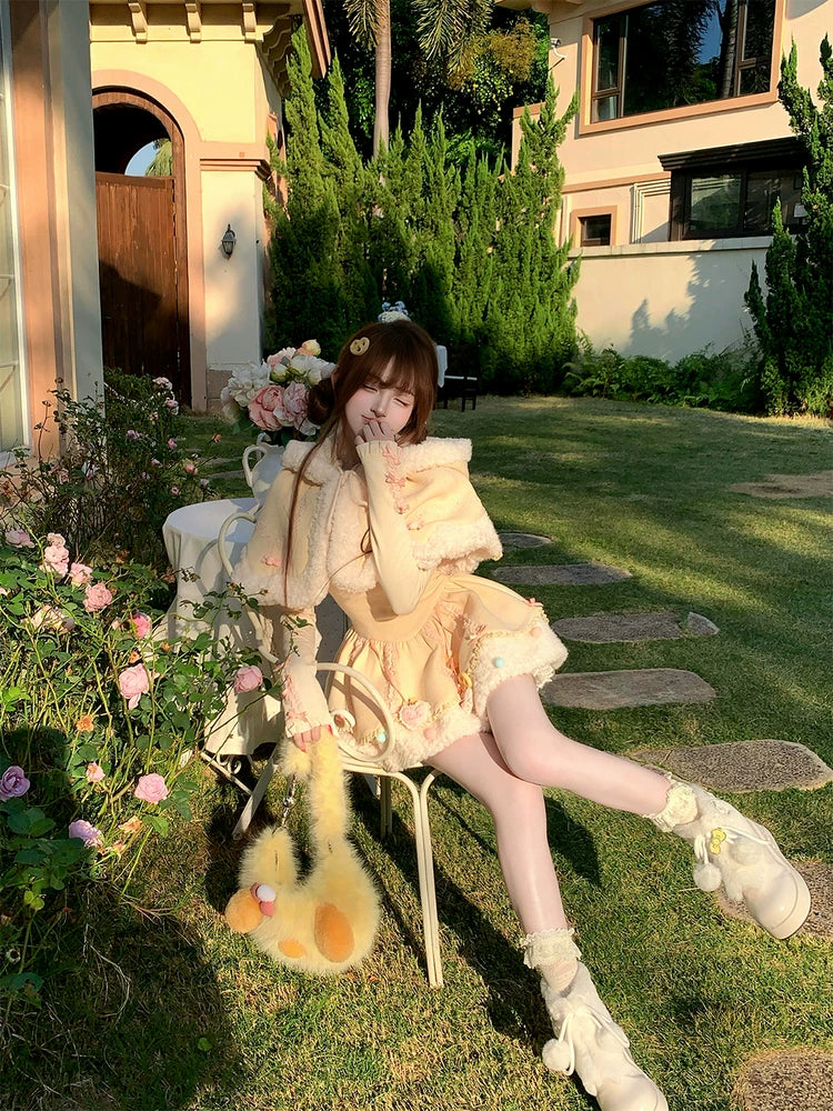 Person in a garden setting with flowers and a building in the background