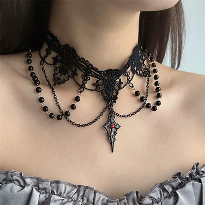 Black lace choker necklace with beads and a pendant on a person wearing a gray top.