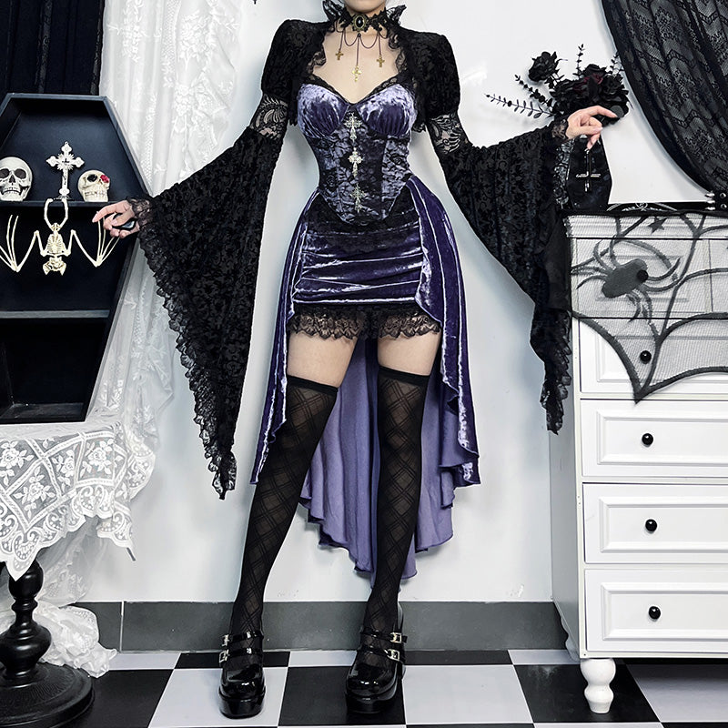 Person wearing a gothic-style outfit with a purple corset and black cloak in a decorated room.
