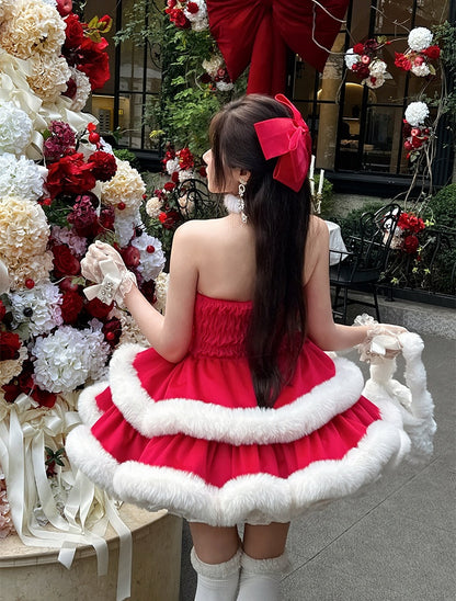 Woman in a red dress with white trim standing in front of floral decorations.