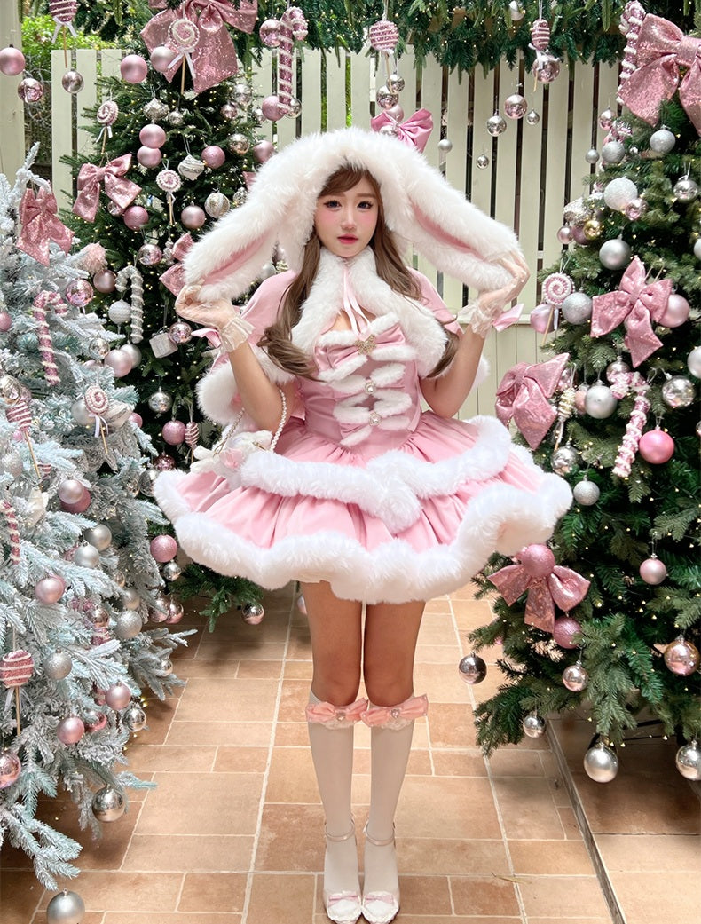 Person in a bunny costume standing in front of decorated Christmas trees.