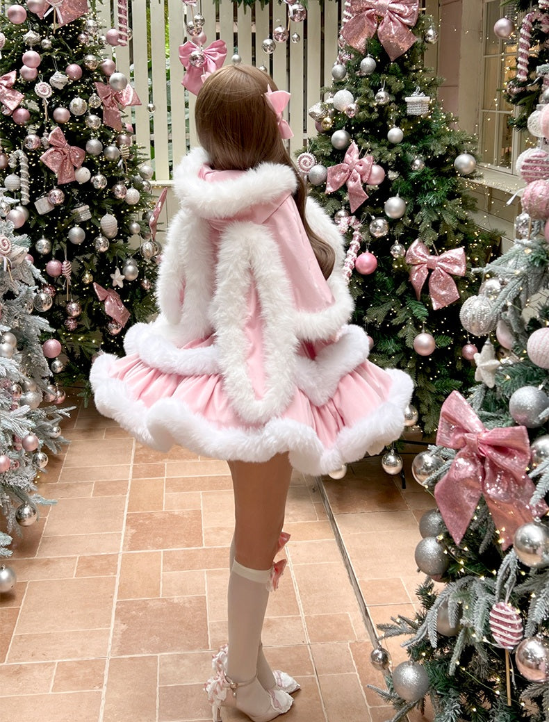 Person wearing a pink dress with white fur trim in front of Christmas trees decorated with pink bows.