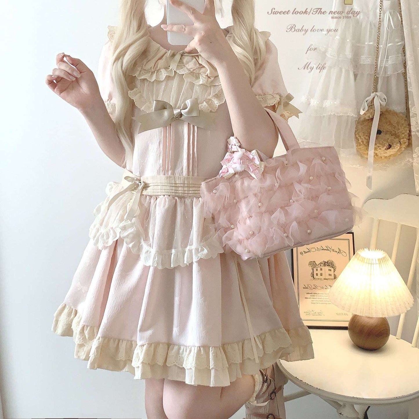 Person wearing a pink and white dress with ruffles, holding a matching handbag in a room.