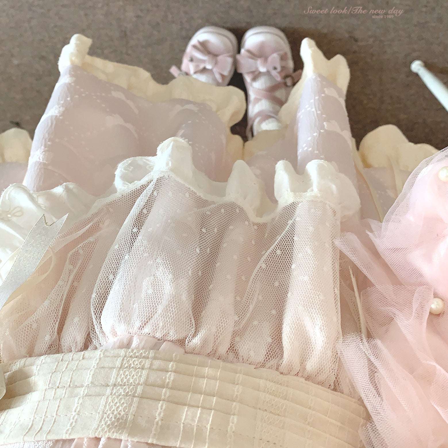 Pink and white dress with matching shoes on a neutral background